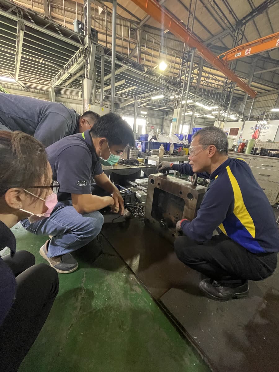 Engineers examining a mold on the shop floor